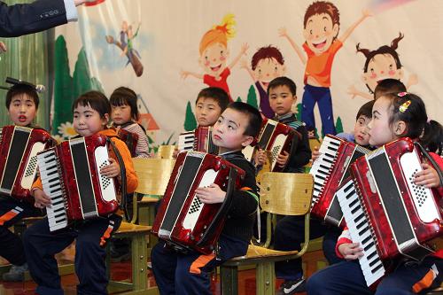 12月24日,北京春江小學(xué)的學(xué)生們?cè)诒硌菔诛L(fēng)琴合奏。新華社發(fā)(周良 攝)