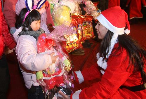12月24日,一名青年志愿者(右)為外來(lái)務(wù)工人員子女送上節(jié)日禮物。 當(dāng)日,遼寧省錦州市商業(yè)系統(tǒng)青年志愿者為20余名外來(lái)務(wù)工人員子女送去禮物,并和他們一起做游戲,讓孩子們體驗(yàn)節(jié)日溫暖。新華社發(fā)(李鐵成 攝)