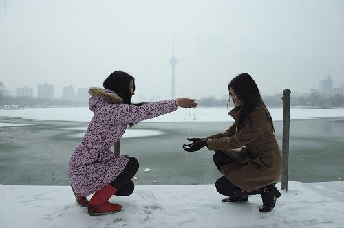 2月10日,兩名從老家剛過(guò)完春節(jié)返京開(kāi)始工作的女孩在北京玉淵潭公園內(nèi)戲雪。新華社記者 楊光 攝
