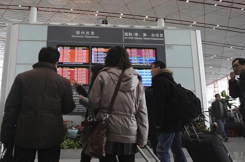 2月10日上午,旅客在首都機場候機大廳瀏覽航班信息。
