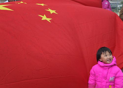 2月28日,中國(guó)駐馬耳他大使館租用的第三艘用于撤離在利比亞中方人員的客輪抵達(dá)馬耳他首都瓦萊塔大港后,一名使館工作人員的孩子站在迎接同胞的國(guó)旗前。新華社記者王慶欽攝