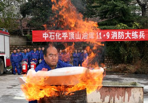 11月8日,演練人員使用滅火毯撲滅“油罐車灌口大火”。新華社發(fā)(王雙正 攝)