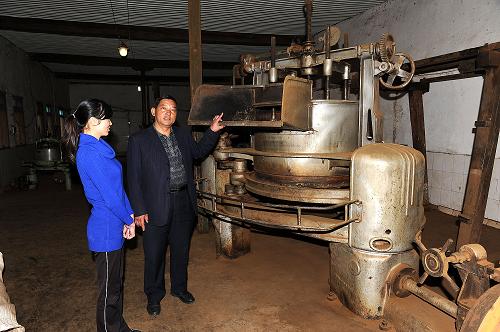 12月25日,參觀者在鳳慶穩(wěn)隆茶葉公司茶文化館里觀看古老的制茶機(jī)。新華社記者 何俊昌 攝