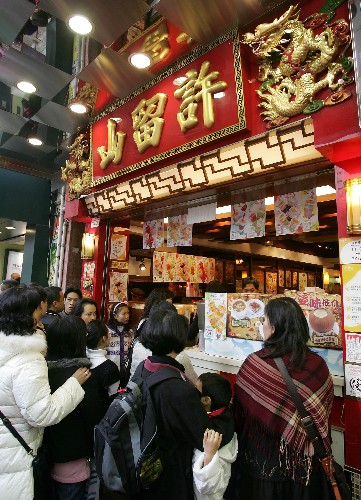 2月9日,一些內(nèi)地游客在香港著名甜品店“許留山”排隊(duì)購(gòu)買甜品。 新華社記者 周磊 攝