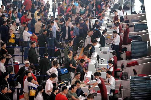 9月29日,旅客在首都機(jī)場(chǎng)排隊(duì)辦理登機(jī)手續(xù)。 新華社發(fā)(荊雷 攝)