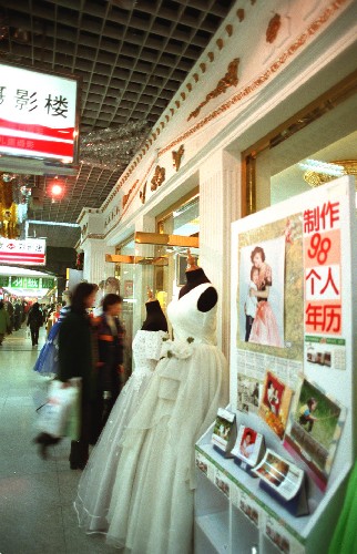 這是1998年春節(jié)期間,北京西單的愛克發(fā)影樓的“個人年歷”吸引了眾多京城百姓。 新華社發(fā)