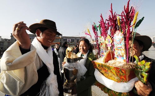 2月7日,拉薩市城關(guān)區(qū)魯古居委會(huì)的居民在大昭寺廣場(chǎng)互敬象征五谷豐登的“切瑪”。