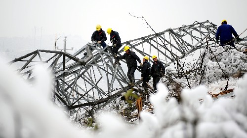 2月6日,來(lái)自河南省電力公司的工程人員在湖南郴州被冰雪壓塌的137號(hào)高壓電塔上施工。
