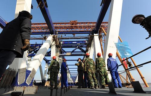 12月17日,建設(shè)者在鄭州黃河公鐵兩用橋上進(jìn)行主橋鋼梁桿件吊裝作業(yè)。新華社記者 趙鵬 攝