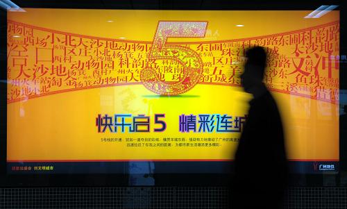 12月28日,一位乘客從廣州地鐵五號(hào)線開通廣告牌前經(jīng)過。新華社記者 劉大偉 攝