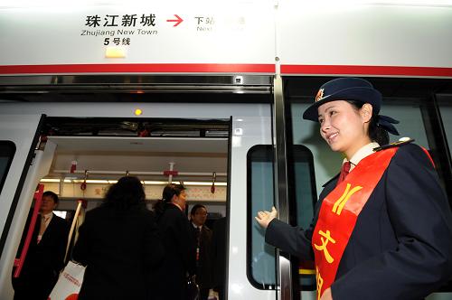 12月28日,廣州地鐵工作人員在五號(hào)線珠江新城站歡迎首趟列車的乘客。