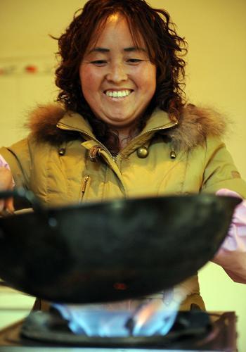 2月7日,綿竹市新市鎮(zhèn)石虎村婦女陶志花在用沼氣爐做飯。她家在地震后建起沼氣池,年節(jié)約燃料支出1000多元。“5·12”特大地震極重災(zāi)區(qū)四川省綿竹市是全國農(nóng)村能源綜合建設(shè)先進(jìn)縣(市)。在地震之前,該市有8.1萬戶農(nóng)戶使用沼氣。地震后,該市在集中點規(guī)劃建設(shè)農(nóng)戶新房,原來的沼氣池停用、損毀6萬口。2009年,綿竹市投入1.175億元興建2.5萬口農(nóng)村戶用沼氣池(一池三改),這筆資金投入是綿竹市近30年投入農(nóng)村沼氣池資金的總和。今年該市還將新建農(nóng)村戶用沼氣池4萬口。農(nóng)村沼氣的使用大大改變農(nóng)村家園面貌,提高農(nóng)民生活質(zhì)量,大大減少煤炭的使用量,同時有效降低農(nóng)民能源支出。新華社記者 李曉果 攝