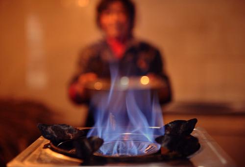 2月7日,綿竹市一位農(nóng)民準(zhǔn)備用沼氣爐做飯。新華社記者 李曉果 攝