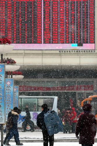 2月7日,一位農(nóng)民工(中)準(zhǔn)備從哈爾濱火車站坐火車回家。新華社記者王松攝