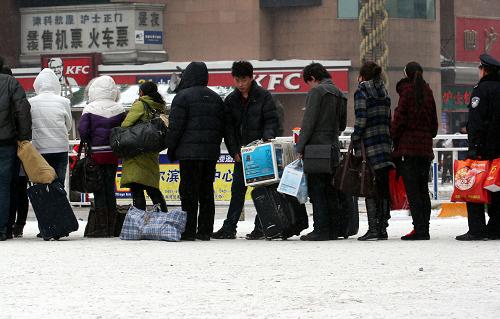 2月7日,回鄉(xiāng)的人們在哈爾濱火車站前廣場排隊(duì)等待出租車。新華社記者王松攝