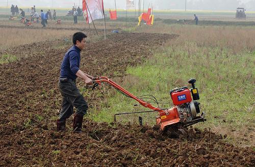 2月28日,潼南縣春耕生產(chǎn)會現(xiàn)場,農(nóng)民使用微耕機(jī)犁地。新華社記者 陳誠 攝