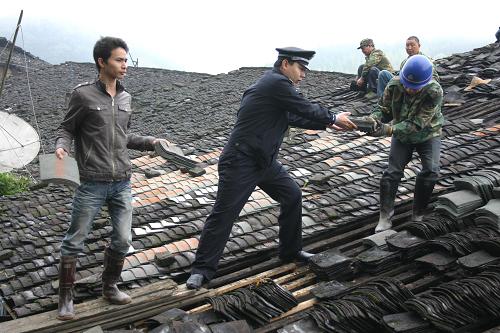 3月6日,福建省順昌縣仁壽公安派出所民警幫助農(nóng)民修繕遭冰雹襲擊損壞的房屋。新華社發(fā)(陳柏材 攝)