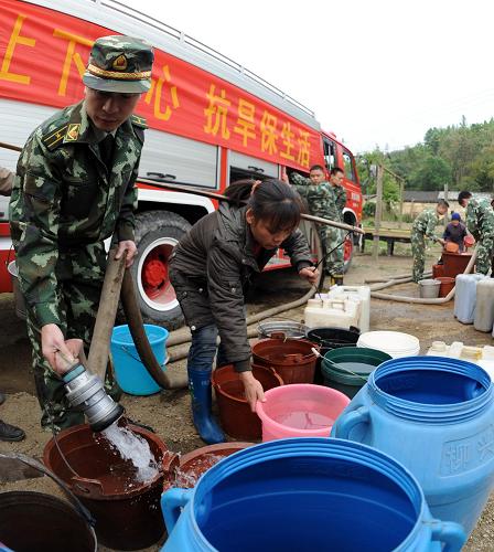 武警官兵為廣西來賓市的受災(zāi)群眾送水(3月25日攝)。新華社記者張愛林攝