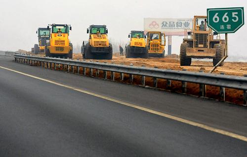 3月30日,在連霍高速公路改擴建工程鄭州境內(nèi)的一個工地上,幾臺壓路機在碾壓新鋪設(shè)的路基。新華社記者王頌攝