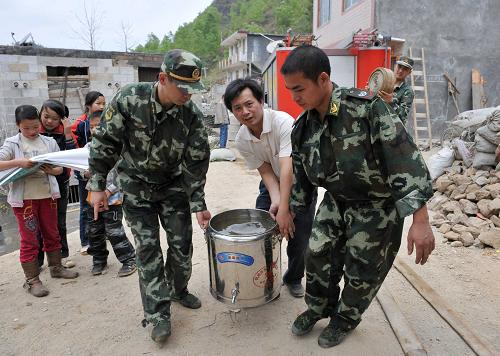 3月30日,在廣西那坡縣龍合鄉(xiāng)智合村,消防官兵在幫助群眾抬水。新華社記者 周華 攝