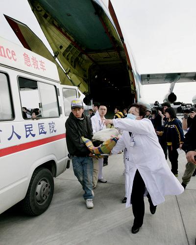 4月15日,來自青海玉樹地震災區(qū)的傷員抵達成都雙流機場后被護送下飛機,準備送往醫(yī)院。新華社發(fā)(劉應華 攝)