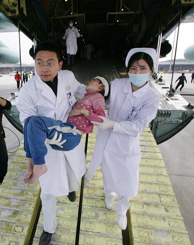 4月15日,來自青海玉樹地震災區(qū)的小傷員抵達成都雙流機場后被護送下飛機。新華社發(fā)(劉應華 攝)