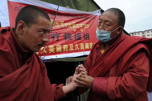 4月20日,一名藏醫(yī)(右)在受災(zāi)群眾安置點為一位喇嘛診斷病情。新華社記者朱祥攝