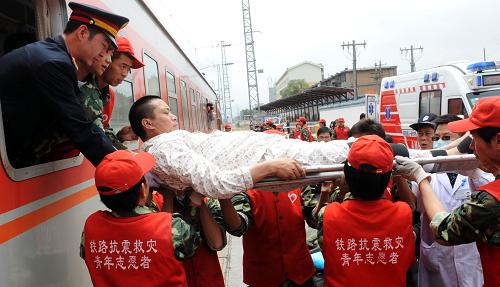 6月1日,在西寧車站,列車員、鐵路青年志愿者將傷員抬下火車。新華社記者 侯德強 攝
