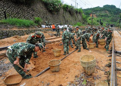 這是武警南平支隊官兵緊急搶修外南線,清理淤泥沙石(6月15日攝)。6月15日23時55分,記者從南昌鐵路局了解到,由于福建境內(nèi)連日持續(xù)強(qiáng)降雨,經(jīng)南昌鐵路局奮力搶通、基本恢復(fù)運(yùn)行的鷹廈、贛龍和外南線,15日又有8處地段先后出現(xiàn)不同程度的水害或塌方險情,造成進(jìn)出福建的部分旅客列車受到較嚴(yán)重影響。目前,南昌鐵路局正組織搶險人力及機(jī)具、路料,全力進(jìn)行線路搶修,力爭盡快搶通,恢復(fù)列車運(yùn)行。目前,為保證動車組運(yùn)行絕對安全,南昌鐵路局對福廈線兩個降雨量大且地質(zhì)情況復(fù)雜的區(qū)段,動車組實行每小時160公里限速運(yùn)行。新華社記者 魏培全 攝