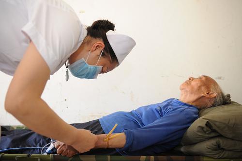 7月4日,臨時安置點衛(wèi)生室護士在為80歲的陳興鳳老人輸液治療?;挤尾扛腥镜年惻d鳳老人在醫(yī)務(wù)人員的及時醫(yī)治下,病情很快得到控制。新華社記者 劉續(xù) 攝