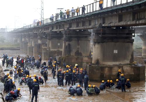 7月25日,在隴海鐵路陜西寶雞千河大橋下,搶險工人在編制鐵絲籠,準備加固橋墩。新華社發(fā)(張劍 攝)