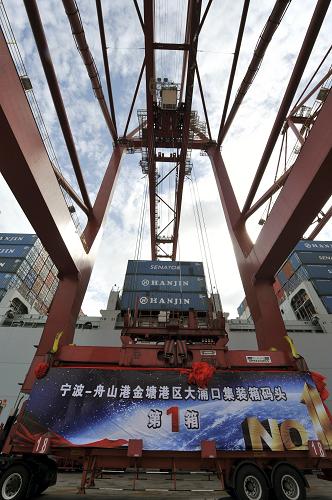 7月25日,寧波—舟山港金塘港區(qū)大浦口集裝箱碼頭工作人員為??看a頭的首航船裝貨。新華社發(fā)