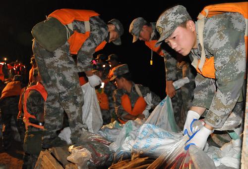7月28日凌晨,武警官兵、解放軍戰(zhàn)士及吉林省干部群眾正在飲馬河堤防連夜加固堤壩。新華社記者齊海山攝