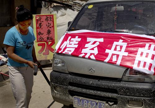 8月15日,甘肅岷縣居民張旺旺準(zhǔn)備為前往災(zāi)區(qū)的車輛加水。 自甘肅舟曲特大泥石流災(zāi)害發(fā)生以來,離舟曲150公里的岷縣成為全國各地向舟曲運(yùn)送物資的中轉(zhuǎn)站。岷縣國道附近的老百姓也自發(fā)組織起來,為過往運(yùn)送物資的車輛提供免費(fèi)供水、洗車,食宿等服務(wù),為災(zāi)區(qū)救援貢獻(xiàn)自己的一份力量。新華社發(fā)(劉瀟 攝)