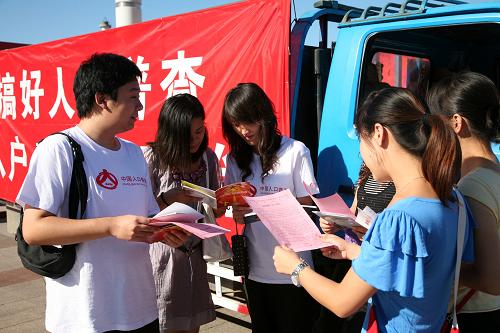 8月15日,北京懷柔區(qū)的人口普查員在街頭進行“入戶登記”宣傳咨詢。新華社發(fā)(卜向東 攝)