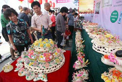 9月11日,觀眾觀賞巨型“忠義關公”大花饃。當日,作為中國運城關公文化旅游節(jié)重要活動之一的非物質文化遺產傳統(tǒng)技藝暨文化精品展在山西運城市河東廣場拉開帷幕,參展的近百家單位以展覽結合展演的形式,展出傳統(tǒng)技藝、民間文學、民俗等10大類75個非遺項目,吸引眾多市民前來觀賞。新華社發(fā)(薛俊 攝)