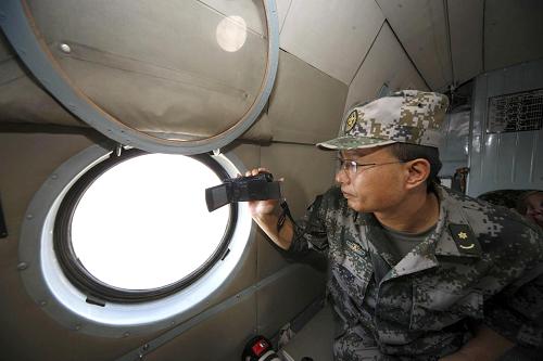 10月8日,在巴基斯坦海德拉巴洪水災區(qū),中國人民解放軍直升機救援隊隨隊航醫(yī)、蘭州軍區(qū)烏魯木齊總醫(yī)院急診科主任沈開金拍攝災區(qū)影像資料。當天是沈開金的生日。新華社記者李翔攝
