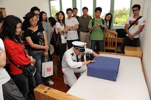 5月1日,一名海軍戰(zhàn)士向市民展示疊軍被。新華社記者 陳鐸 攝