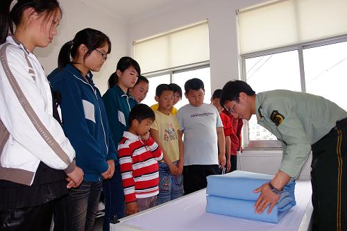 5月17日,民警在為殘障小朋友示范內(nèi)務(wù)整理。新華社記者 朱崢 攝