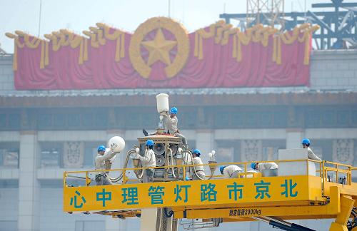 5月26日,工人在清掃檢修北京天安門廣場的華燈。當(dāng)日起,北京市電力公司路燈管理中心開始對天安門廣場周邊和長安街沿線249基華燈進(jìn)行清洗和檢修,同時(shí)換掉不符合要求的燈泡,以迎接新中國六十華誕。新華社記者 羅曉光 攝