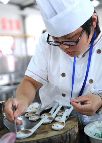 6月28日,一位參賽選手在進(jìn)行中餐熱菜項(xiàng)目的比賽。新華社記者 劉海峰 攝