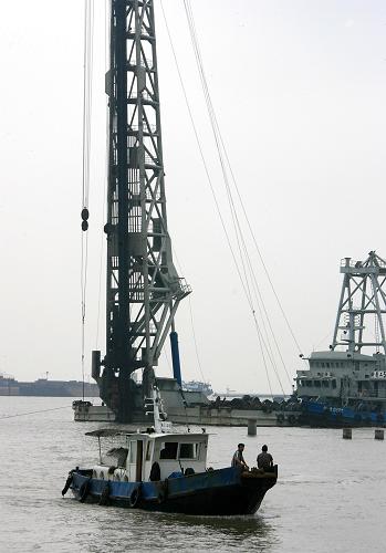 7月28日,船只從上海國(guó)際郵輪碼頭引橋工地前經(jīng)過。近日,上海吳淞口國(guó)際郵輪港水上項(xiàng)目正式開工建設(shè),計(jì)劃于2010年上海世博會(huì)前完工投入使用。作為上海黃浦江第二座郵輪碼頭,該碼頭建成后可同時(shí)停靠10至15萬(wàn)噸級(jí)大型郵輪3艘,預(yù)計(jì)每年可為80萬(wàn)人次的國(guó)內(nèi)外游客提供候船、通關(guān)、換乘、旅游等多項(xiàng)服務(wù)。屆時(shí),乘坐大型國(guó)際郵輪來滬游客可直接通過水路換乘,直達(dá)世博會(huì)場(chǎng)館。新華社記者 陳飛 攝