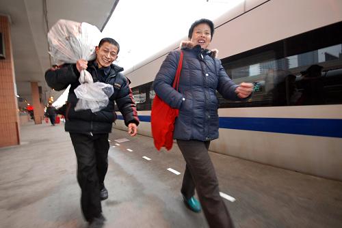2月3日,在杭州火車站,來自江西省南昌縣的農(nóng)民工陳建國與妻子趕乘動車組返鄉(xiāng)。春節(jié)臨近,舒適快捷的“和諧號”動車組成為部分外來務(wù)工人員返鄉(xiāng)過年的新選擇。新華社發(fā)(黃宗治 攝)