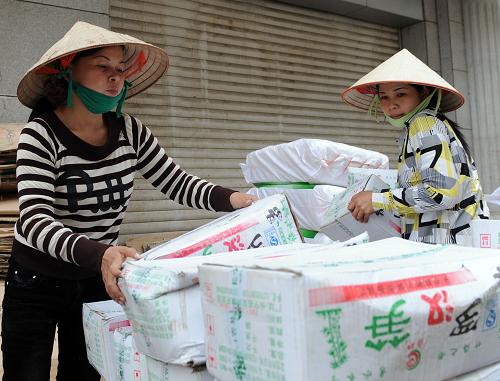2月5日,兩名越南婦女在浦寨邊貿(mào)區(qū)搬運貨物。新華社記者 張愛林 攝
