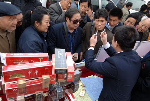 3月15日,在西安市新城廣場,西安市煙草專賣局一分局的工作人員在為群眾講解識別假煙的訣竅。當(dāng)日是國際消費者權(quán)益日,陜西省消協(xié)聯(lián)合省工商局、省質(zhì)量技術(shù)監(jiān)督局、陜西出入境檢驗檢疫局以及33家專業(yè)質(zhì)檢技術(shù)機構(gòu),在西安市新城廣場受理消費者咨詢投訴,并現(xiàn)場提供偽劣產(chǎn)品識別、免費檢測等服務(wù)。新華社記者 丁海濤 攝