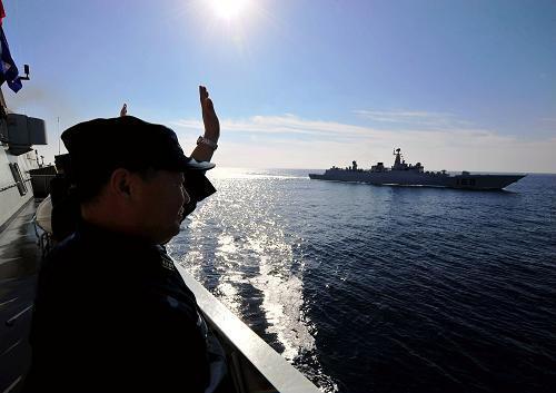 3月15日,在亞丁灣海域,“馬鞍山”艦中國海軍第四批護(hù)航編隊指揮所成員(前)揮手歡迎中國海軍第五批護(hù)航編隊到來。新華社記者 楊志剛 攝