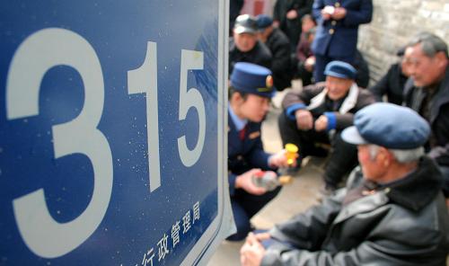 3月15日,山東省巨野縣工商執(zhí)法人員向農(nóng)民介紹辨別商品真?zhèn)蔚姆椒?。新華社發(fā)