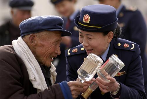 3月15日,山東省巨野縣工商執(zhí)法人員向農(nóng)民介紹辨別商品真?zhèn)蔚姆椒?。新華社發(fā)