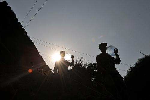 3月31日,在廣西那坡縣百南鄉(xiāng)弄民村三支屯,解放軍官兵給村民送水后返程。新華社記者 周華 攝