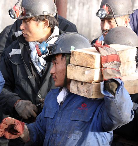 4月1日,救援人員扛著木塊準備下井,這些木塊用來墊在抽水管道下面,保持管道平穩(wěn),盡快排水。新華社記者 高學余 攝